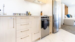 Een moderne keuken met licht houten kastjes, roestvrijstalen apparatuur en een inbouwoven.