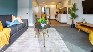 Uma sala de estar moderna com sofá, mesa de centro e área de jantar com cadeiras.