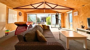 A cozy living room with a wooden ceiling, a sofa, a coffee table, and a TV.