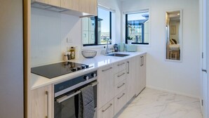 Una cocina moderna con horno empotrado, estufa y lavaplatos.
