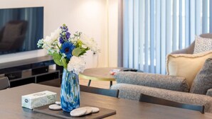 A modern living room with a dining table, a vase of flowers, and a sofa. - Urban comfort and parking near Avebury Park (Christchurch)
