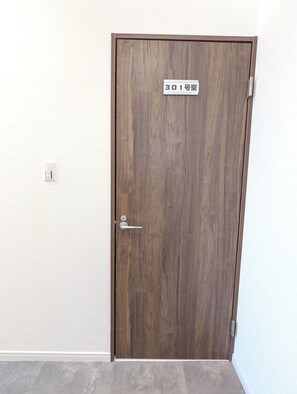 A wooden door with a sign indicating room number 301.