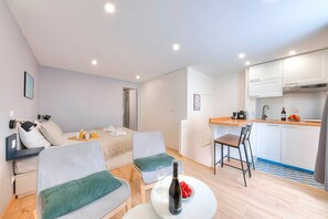 A modern, well-lit apartment with a living area, a dining space, and a kitchenette. - TheBlueStay 206 - Contemporary and modern studio (Paris)