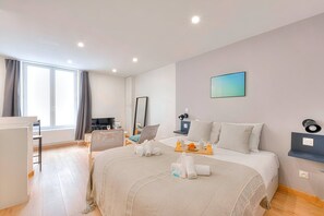 A modern hotel room with a large bed, a desk, a chair, a TV, and a window with curtains. - TheBlueStay 206 - Contemporary and modern studio (Paris)