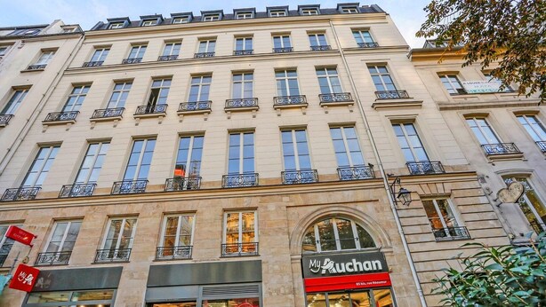 A multi-story building with a ground-floor shop named "My Ruchan" and a red sign above it.