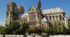 A large Gothic cathedral with intricate architecture, including flying buttresses and a large rose window.