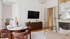 A well-appointed living room with a dining area, a fireplace, and a television mounted on the wall. - TheBlueStay 153 - Outstanding spacious suite - A/C (Paris)