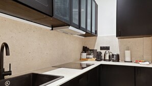 A modern kitchen with a stainless steel sink, black cabinets, and a countertop with kitchen appliances. - TheBlueStay 153 - Outstanding spacious suite - A/C (Paris)