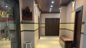 Un pasillo con un banco, un taburete pequeño y una puerta con un panel de madera.