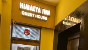 La entrada de un hotel con un letrero que dice 'HIMALAYA INN GUEST HOUSE'.