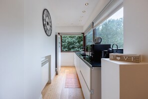 Eine moderne Küche mit Fenster, einer Uhr und einem 'LOVE'-Schild.