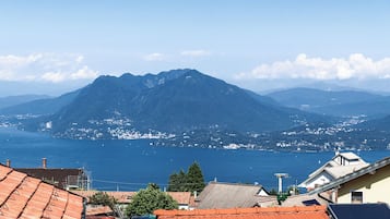 Una montaña con vista despejada al mar y un pueblo al fondo.