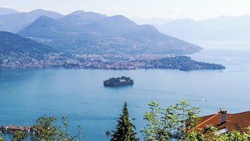 Una vista panoràmica d'un llac amb una petita illa i muntanyes circumdants.