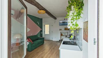 Una cocina moderna con encimera blanca y una planta colgante.