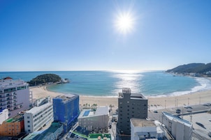 Un paisaje urbano costero con una playa, edificios y cielo despejado.