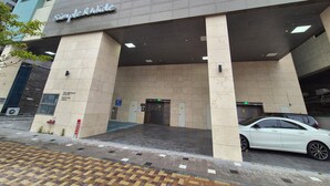 A building with a sign reading "Simple & Wide" and a parking sign indicating a parking area. - The First Ocean Songjung (Busan)