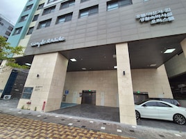 Un edificio con un letrero que dice "Simple & Wide" y una señal de estacionamiento que indica un área de estacionamiento.