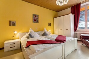 A bedroom with a bed, bedside tables, a wardrobe, and a window with curtains. - Room 'Doppelzimmer 9' with Shared Terrace (Oberkirch)