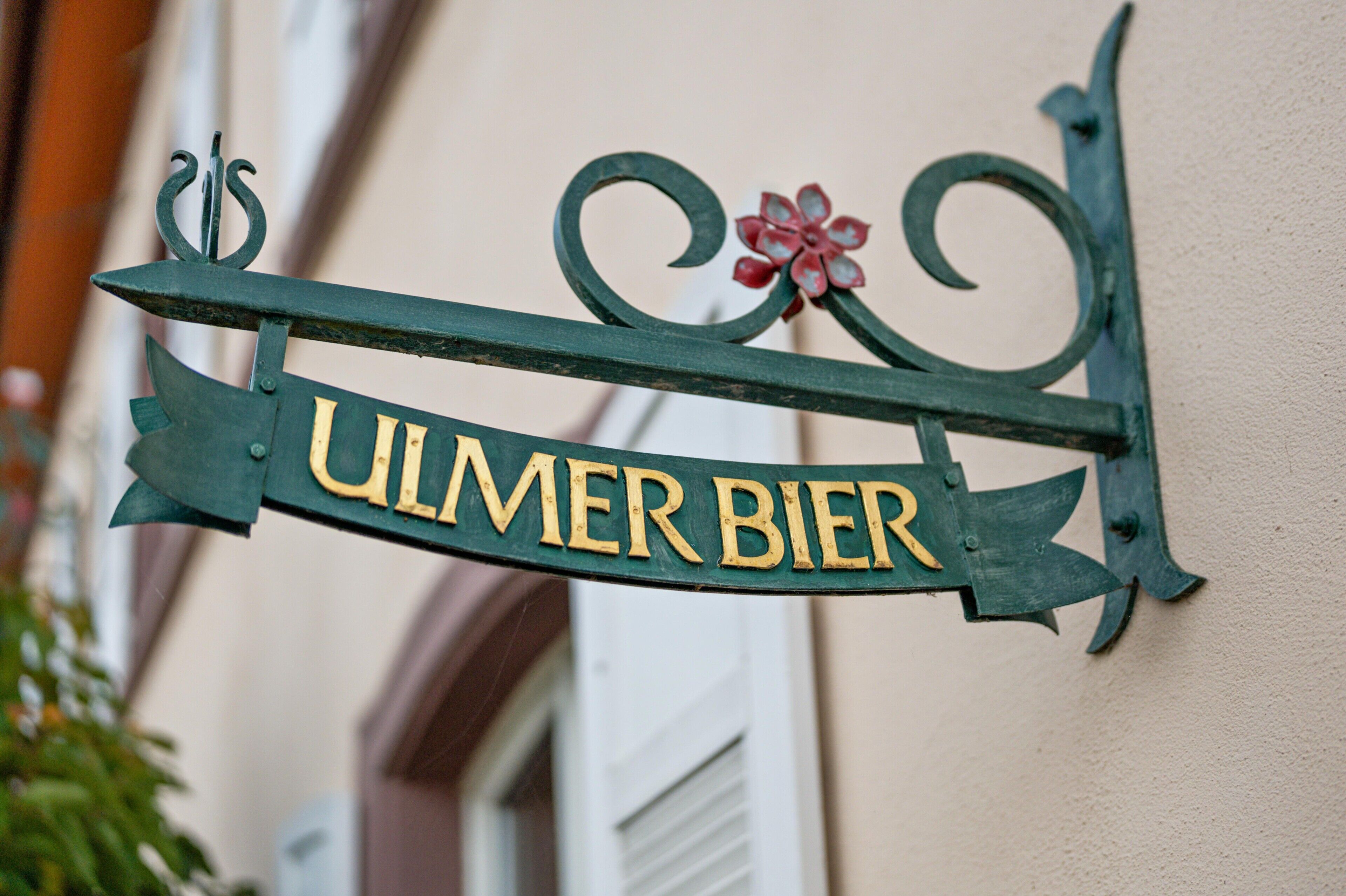 Ein Schild mit dem Schriftzug 'ULMER BIER' an einem Gebäude.
