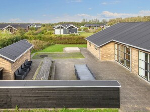 A residential area with modern houses, a paved courtyard, and a wooden deck. - 4 Star Holiday Home in Tarm (Tarm)