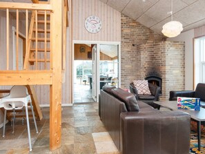 A cozy interior with a brick fireplace, leather seating, and a wooden staircase. - 4 Star Holiday Home in Tarm (Tarm)