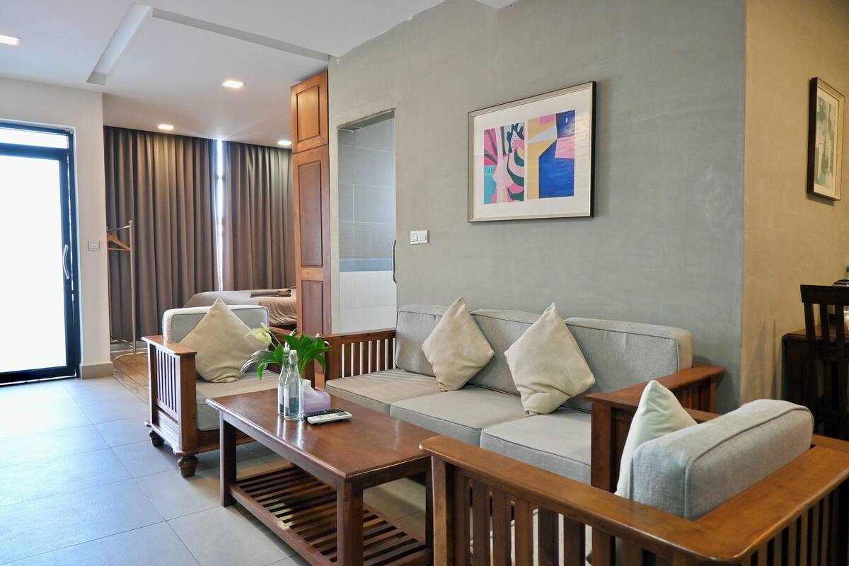A modern living room with a sofa, coffee table, and a painting on the wall.