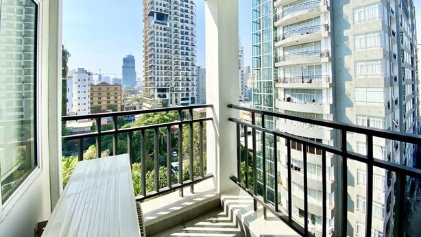 A balcony with a view of high-rise buildings and greenery. - WH Bassac Residence  (Phnom Penh)