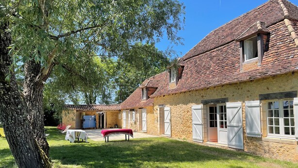 A rustic building with a stone facade, a tiled roof, and a grassy courtyard. - Charming Périgord farmhouse with breathtaking views over the valley and garden (Issac)