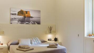 Una camera da letto con un letto, comodini, un tavolino, un quadro e una finestra.