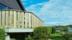 Un edificio moderno con techo inclinado y terraza de madera.