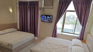 A hotel room with two beds, a TV, and a window with curtains. - Sunmoonstar Hostel (Budai)