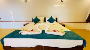 Une chambre d’hôtel avec un lit, des oreillers et des serviettes disposées.