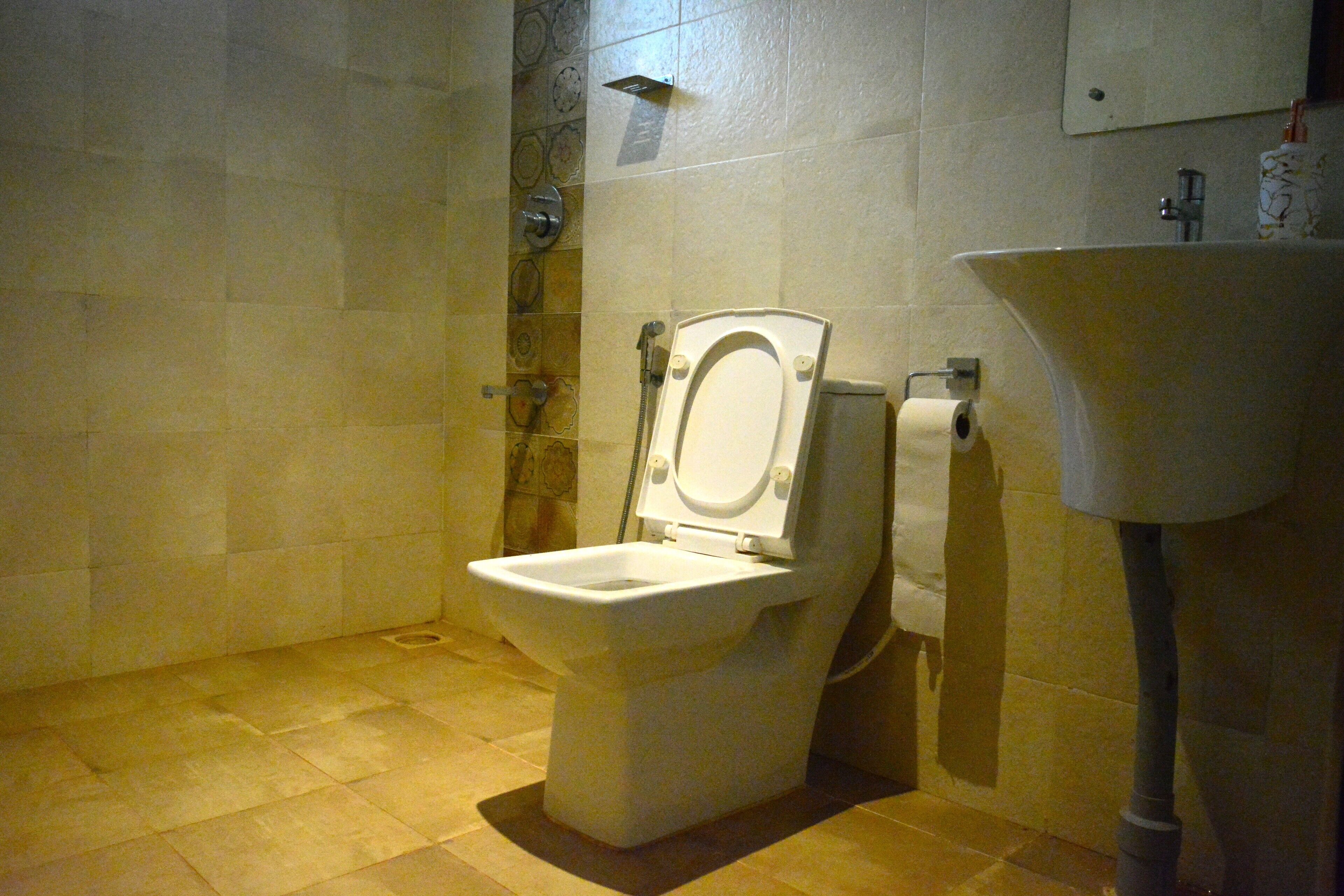 A bathroom with a toilet, a shower, and a sink.