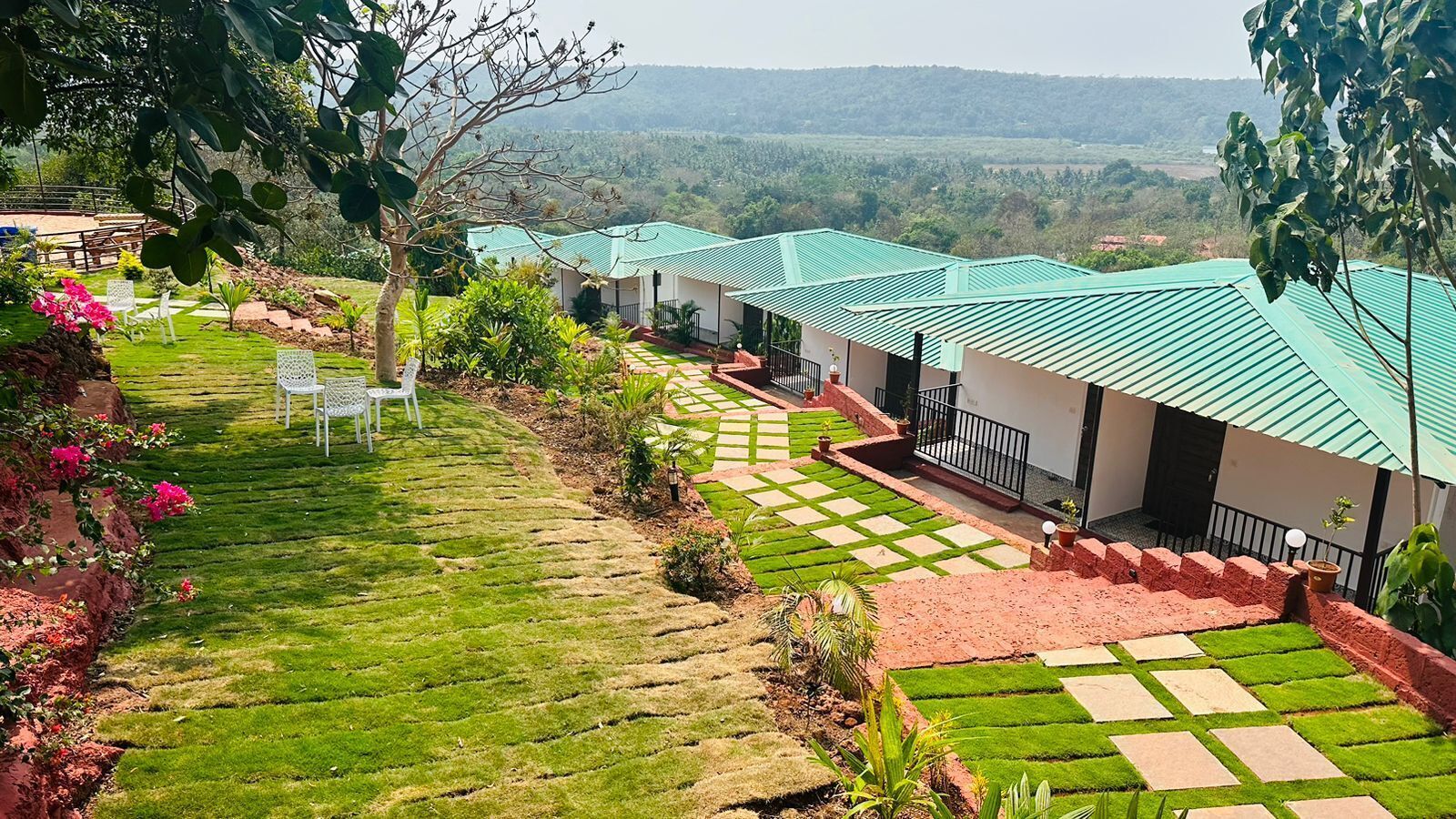 Un hotel con techo verde, césped cuidado y vistas claras del paisaje circundante.