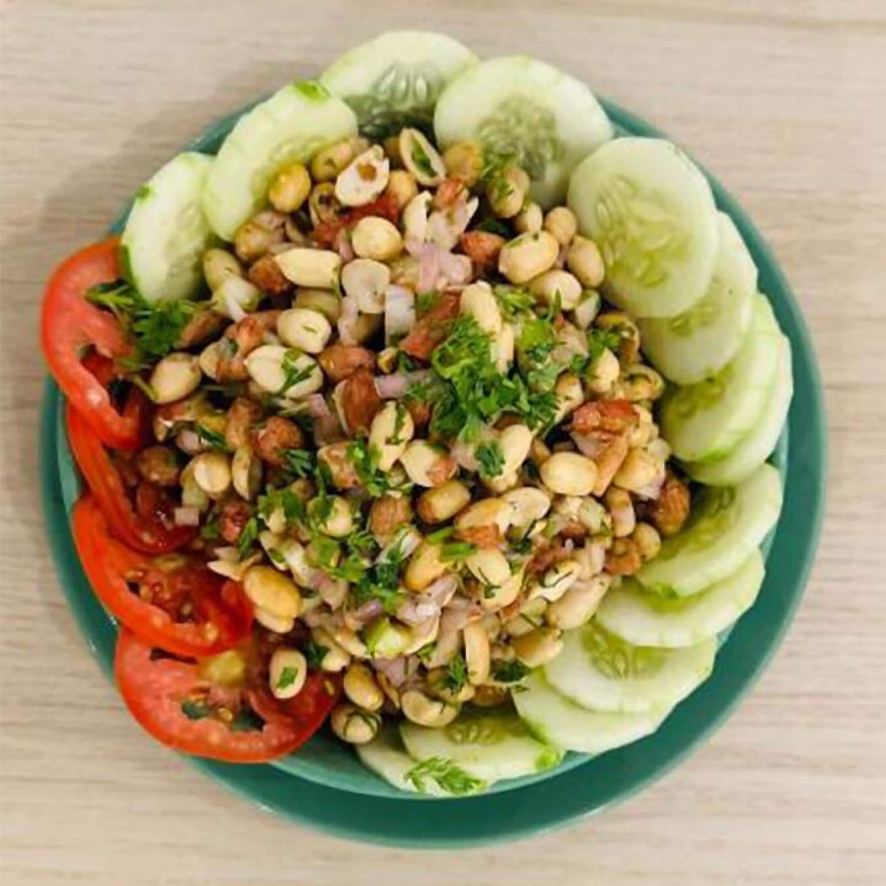 Ensalada con pepinos, tomates y nueces sobre un plato.