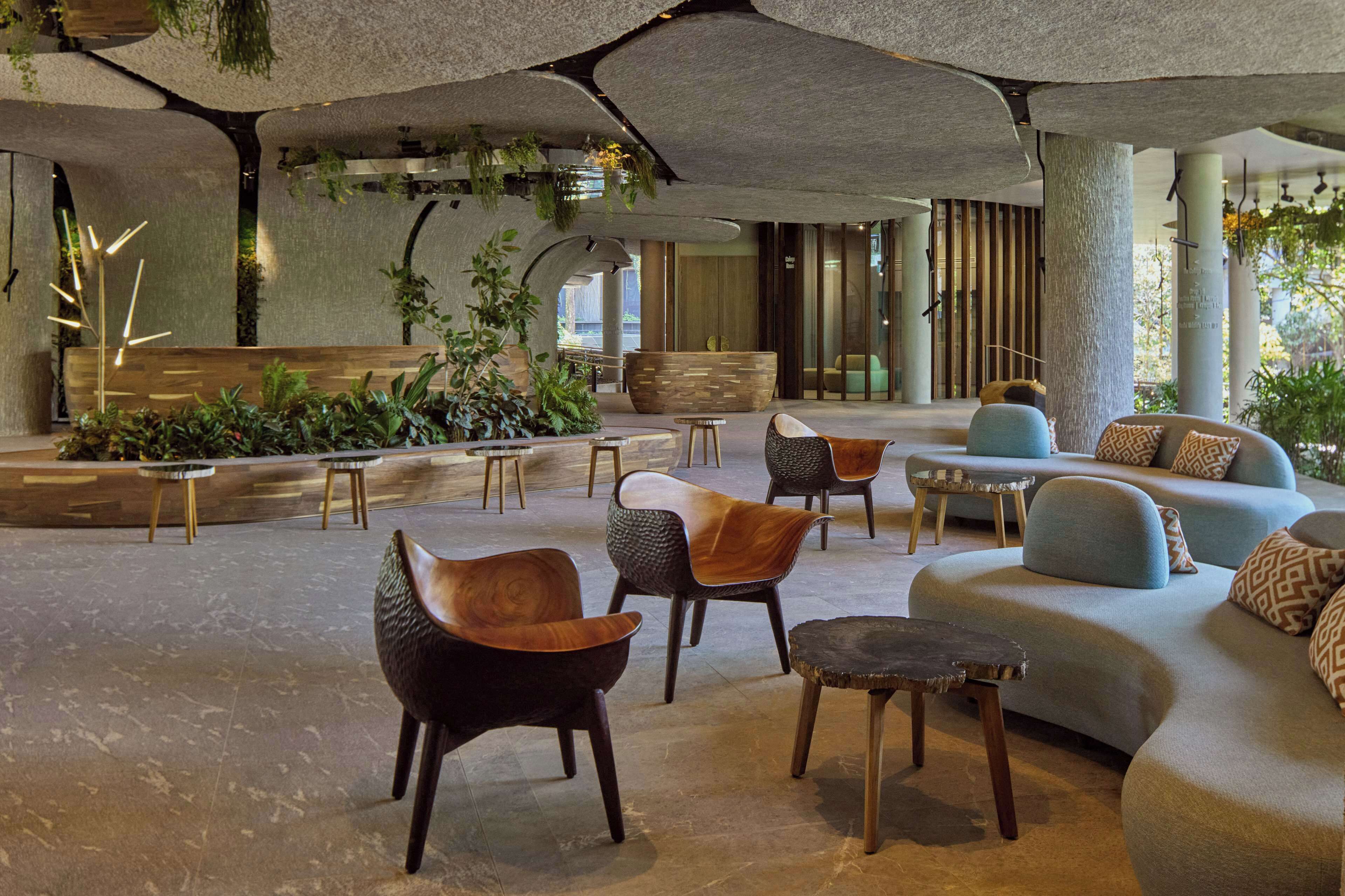 A spacious indoor area with seating arrangements, including sofas and chairs, and a reception desk.