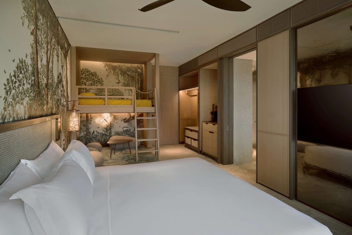 Una camera d'hotel moderna con un letto grande, una scrivania e una televisione.