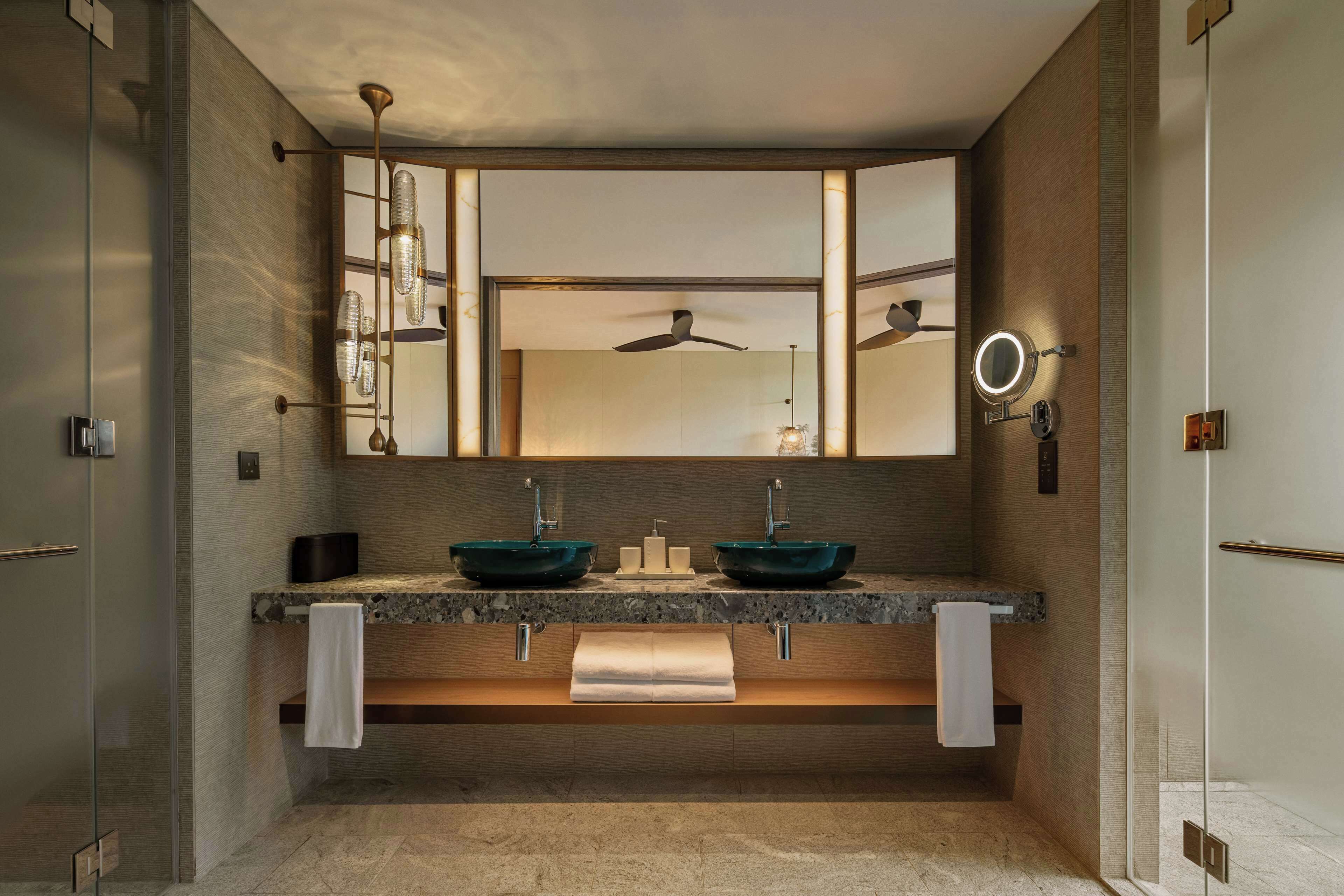 Un baño moderno con lavamanos doble, un espejo grande y un ventilador de techo.