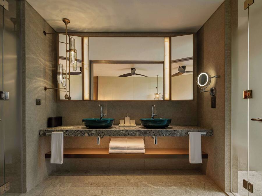 Un baño moderno con lavamanos doble, un espejo grande y un ventilador de techo.