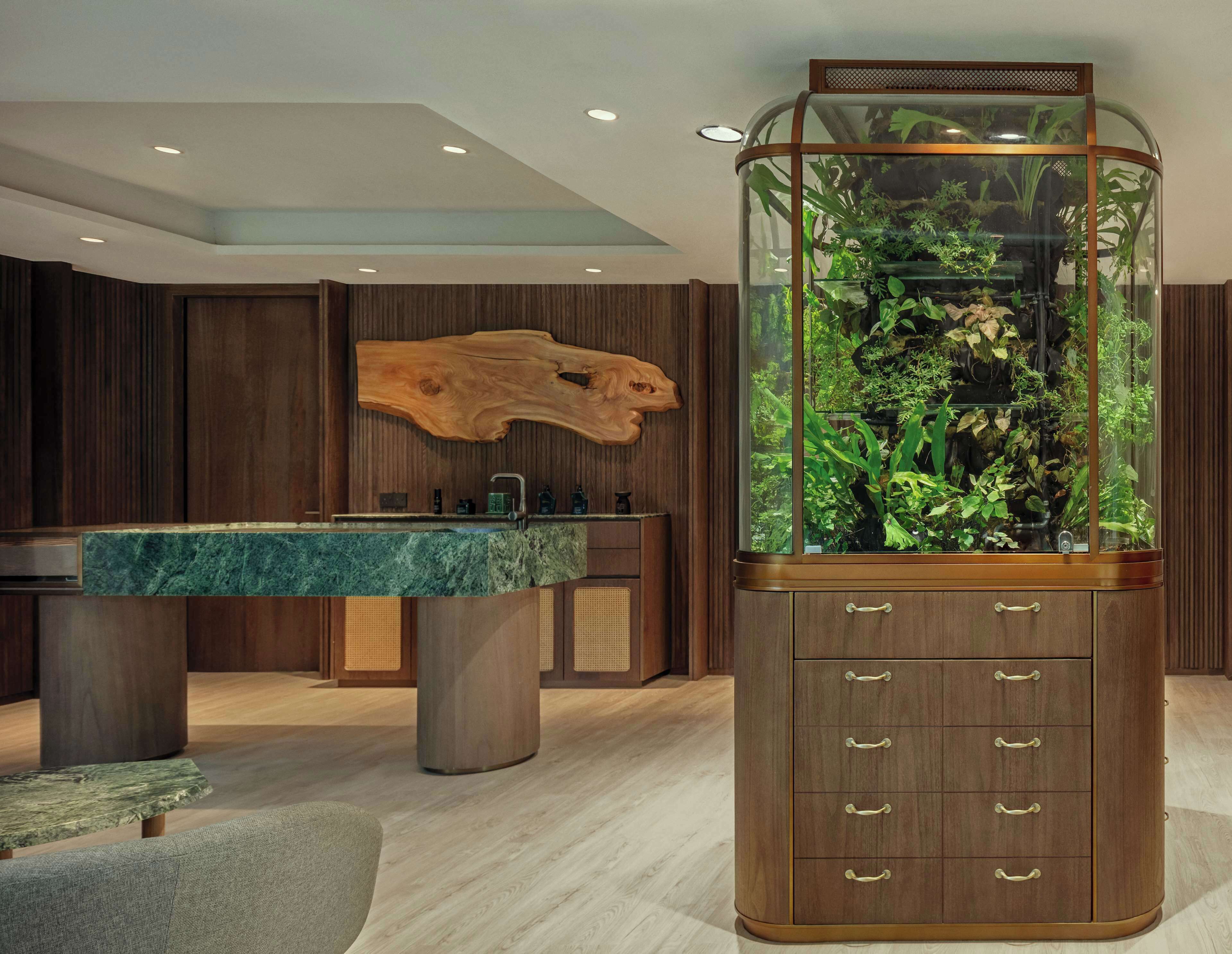 A modern interior with a wooden cabinet, a marble countertop, and a glass aquarium.