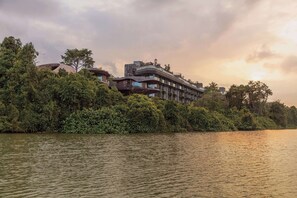 A modern hotel with a unique architecture, situated by a river with dense greenery. - Mandai Rainforest Resort By Banyan Tree (Singapore)