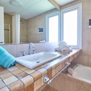 A bathroom with a white sink, a towel rack, and a window. - Punto Playa (Villa Gesell)