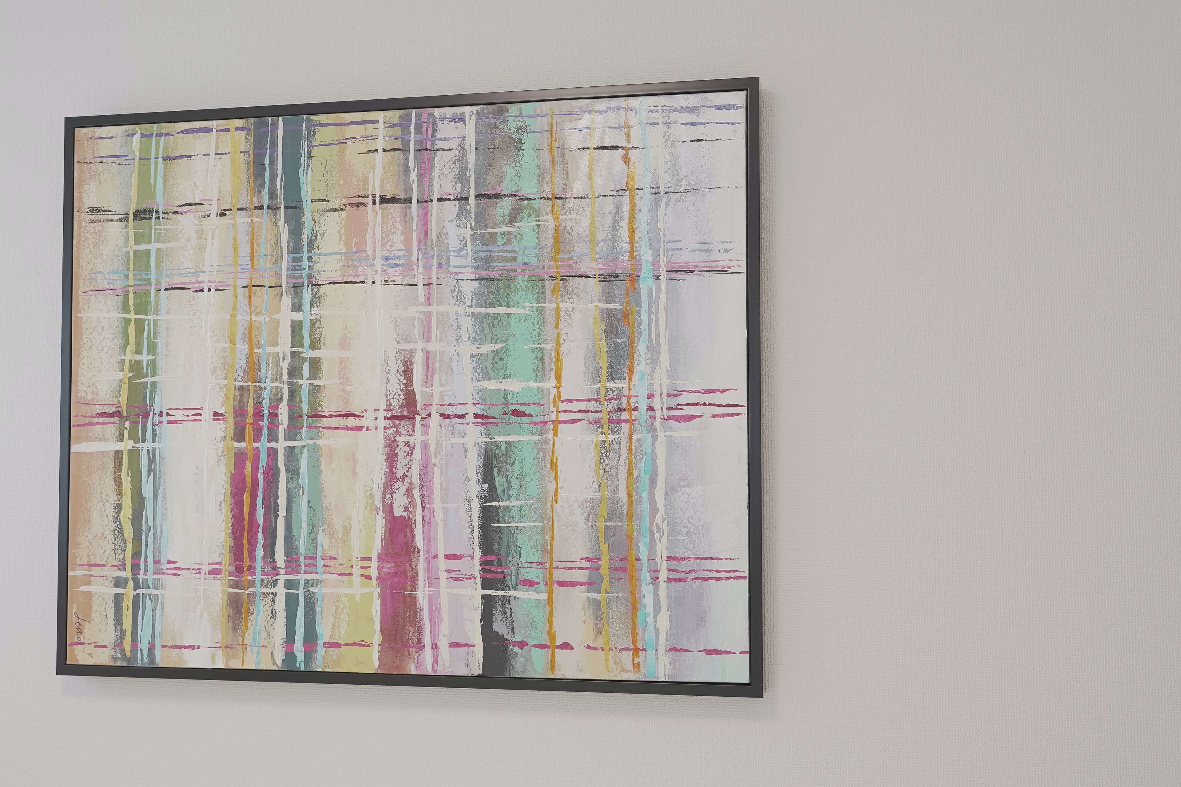 A framed abstract painting with a grid-like pattern and multicolored lines.