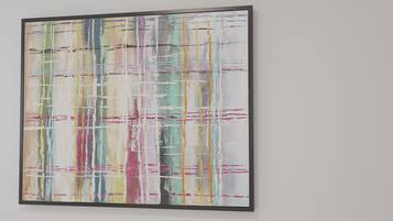 A framed abstract painting with a grid-like pattern and multicolored lines.