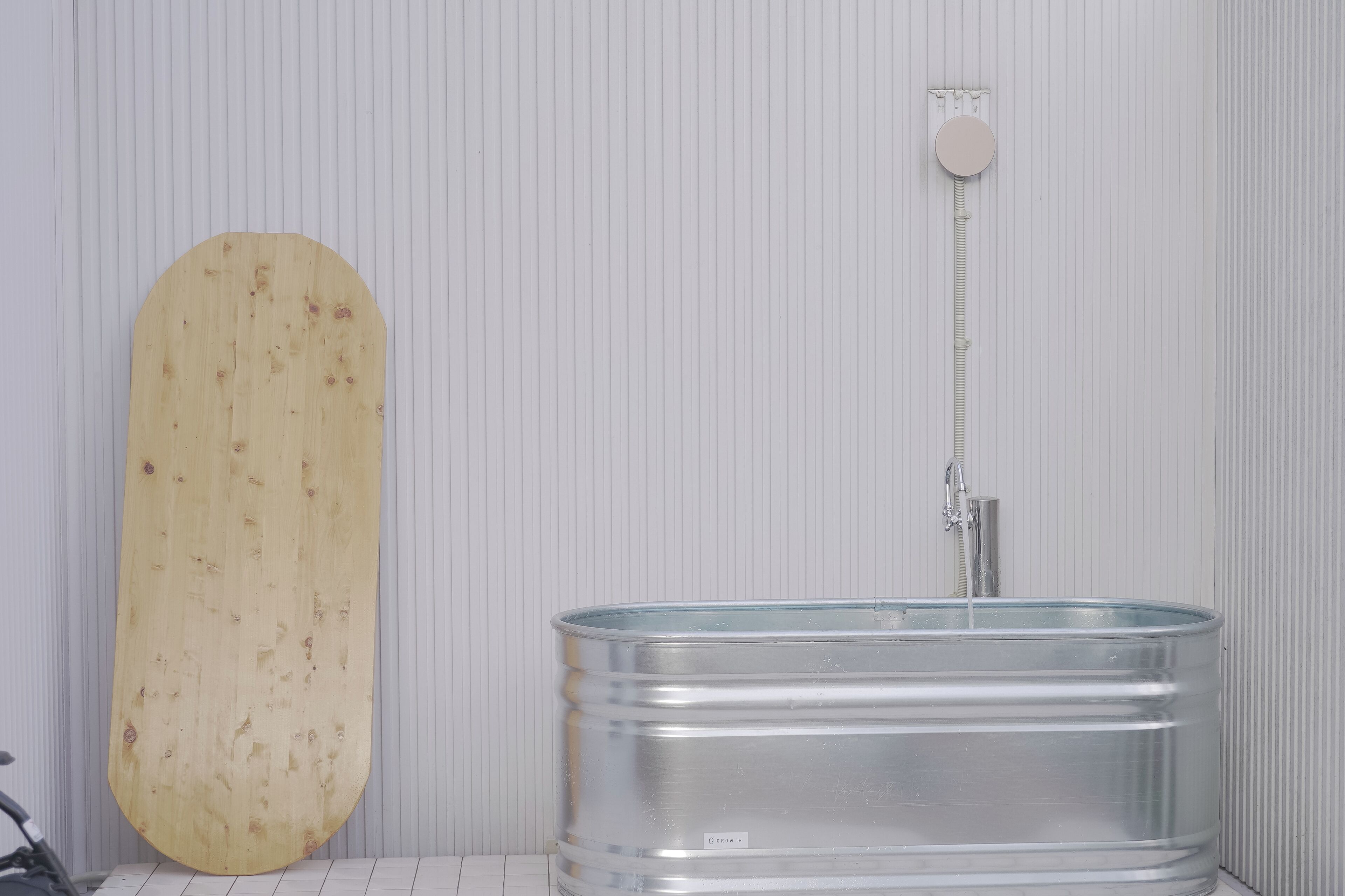 A bathroom with a wooden vanity and a metal sink.