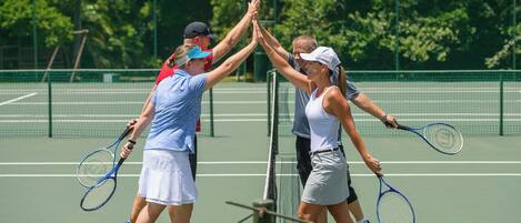 A tennis court with players and a net.