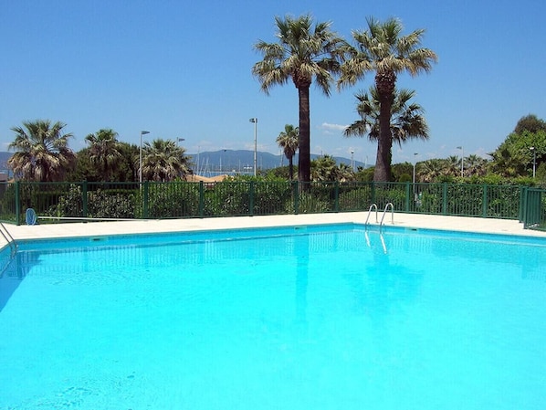 A clear blue pool with a ladder, surrounded by palm trees and a fence. - Apart 4 p, sea view, terraces, swimming pool, A/C (Saint-Raphaël)