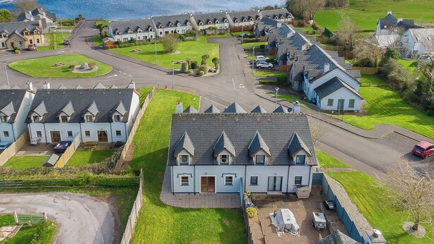 A residential area with houses, a road, and a lake in the background. - 2 bedroom home in Kenmare with sea views to sleep 4 (Kenmare)