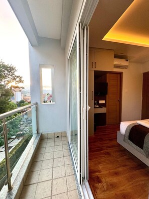 A balcony with a metal railing, a tiled floor, and a view of a cityscape. - Hotel Alleyway Express (Kathmandu)