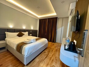 A modern hotel room with a neatly made bed, a flat-screen TV mounted on the wall, and a built-in coffee machine. - Hotel Alleyway Express (Kathmandu)